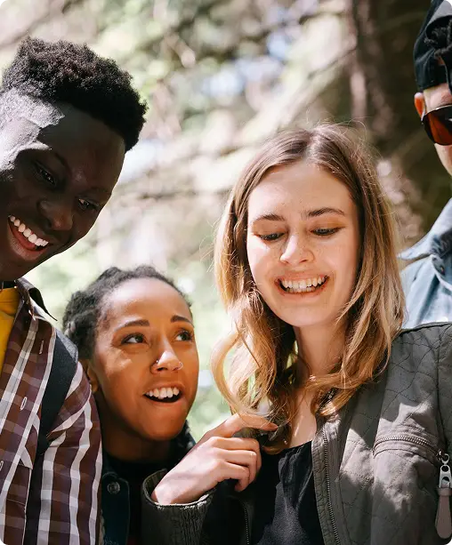 Diverse group of young people smiling together outdoors, representing friendship, collaboration, and community